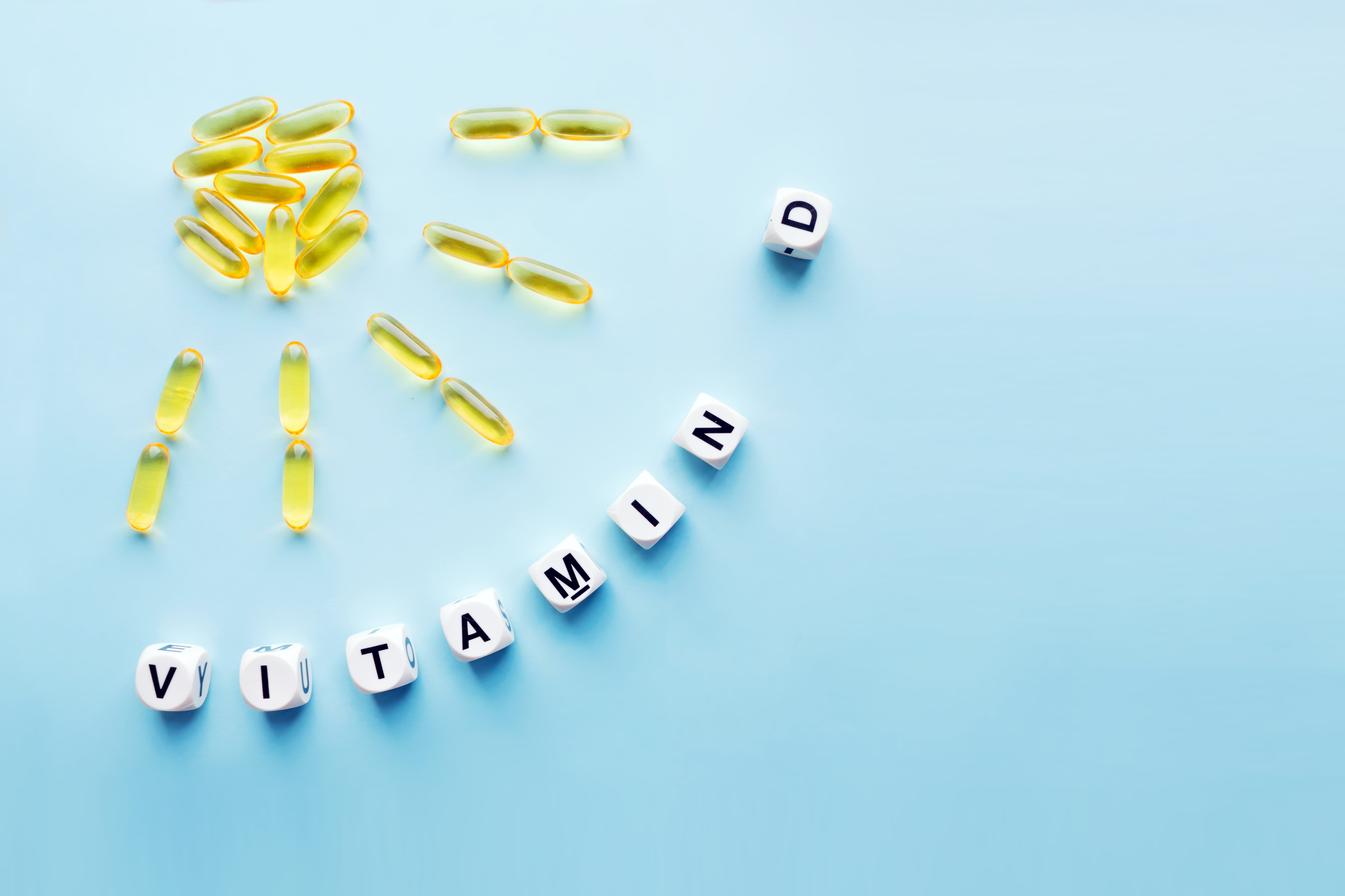 Foto: Iryna Imago/Shutterstock D vitaminpiller formade som en sol och tärningar med texten vitamin D mot en ljusbjå bakgrund