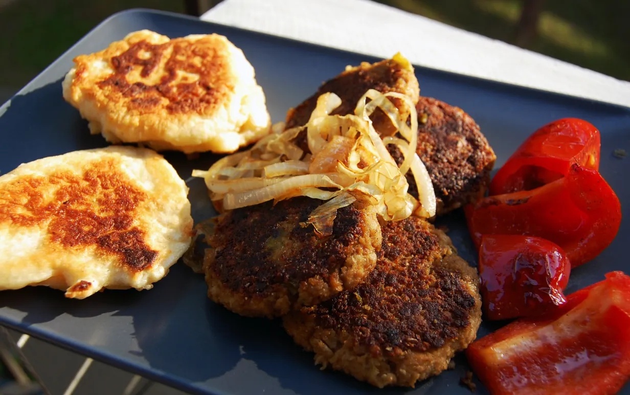 Pljeskavica ligger på ett grått fat