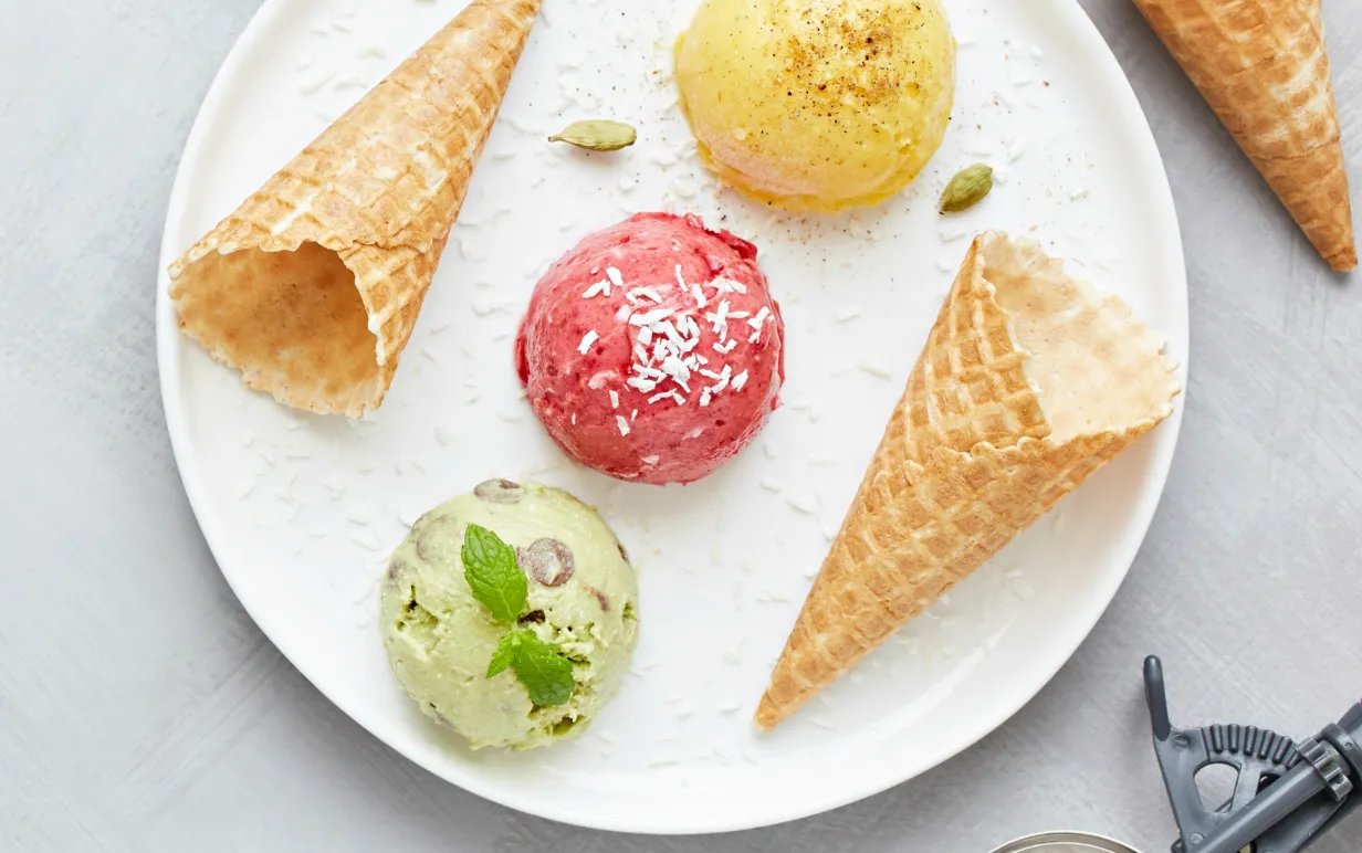 Tre kulor nice cream och två strutar på ett vitt fat.