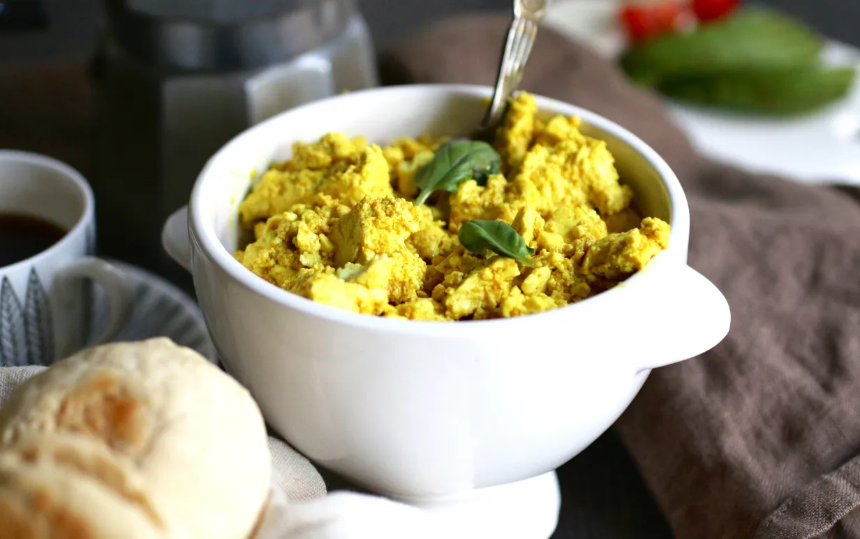 Scrambled tofu i en vit skål på ett bord.