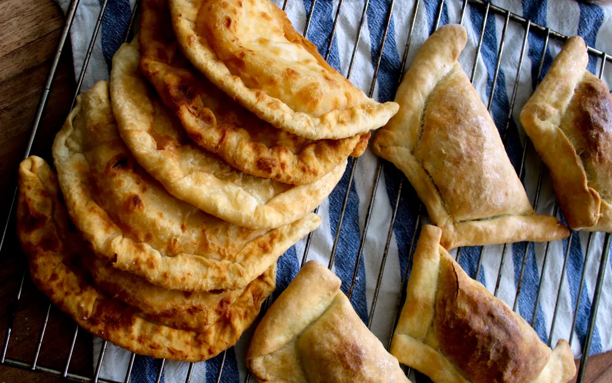 Tofufyllda piroger på en randig handduk bredvid en kavel.