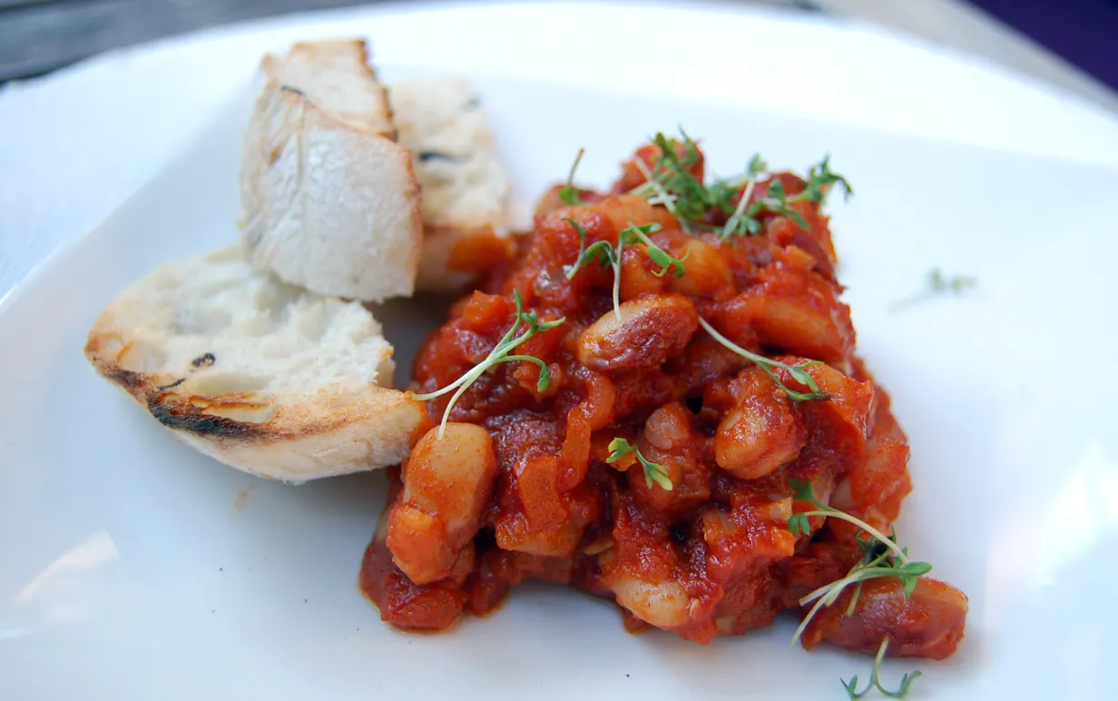 Smokey beans med bröd på en vit tallrik