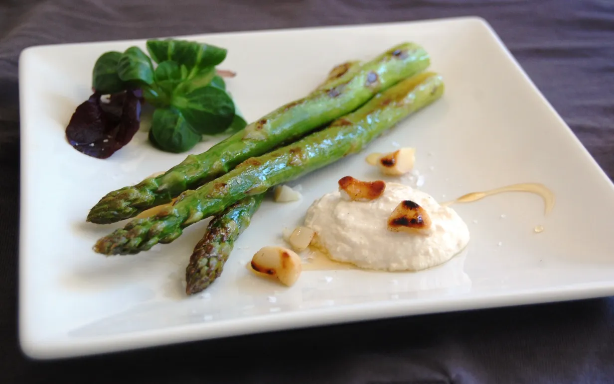 Fräst sparris med vegansk ädelostkräm på en vit tallrik.