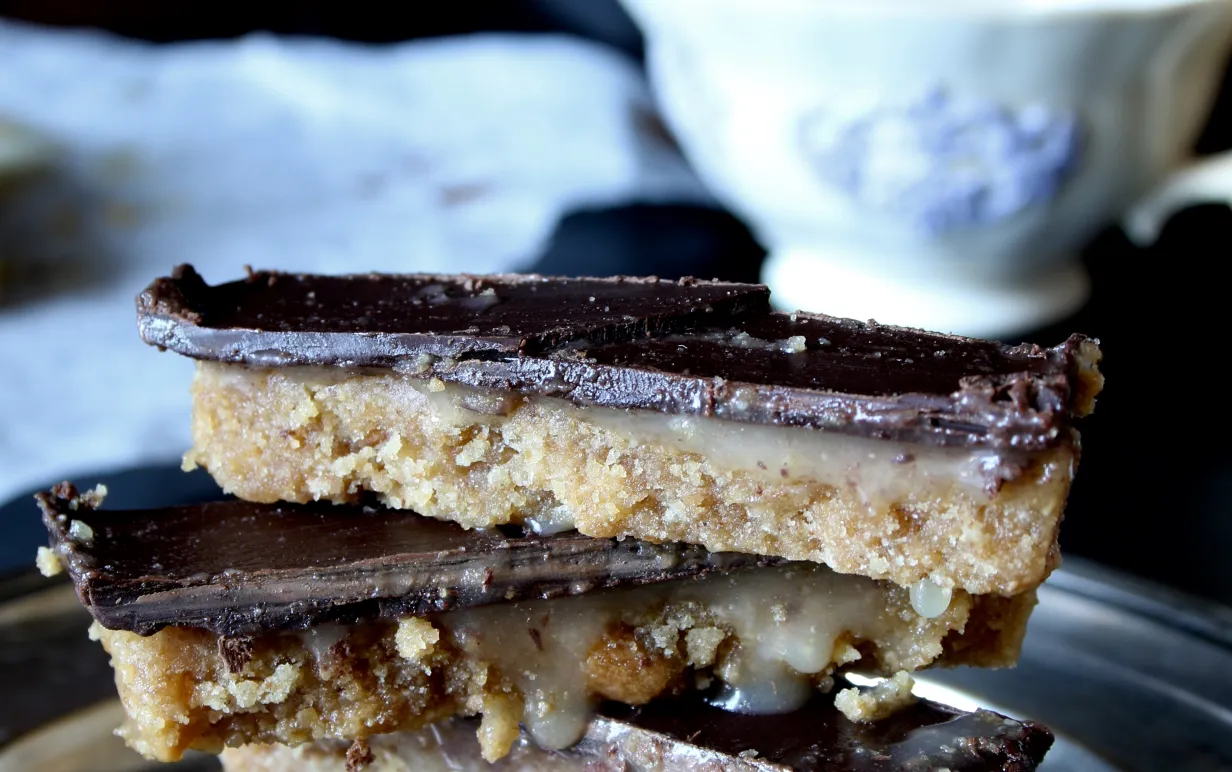 Twix-bitar på ett fat, i bakgrunden står en vit kaffekopp.