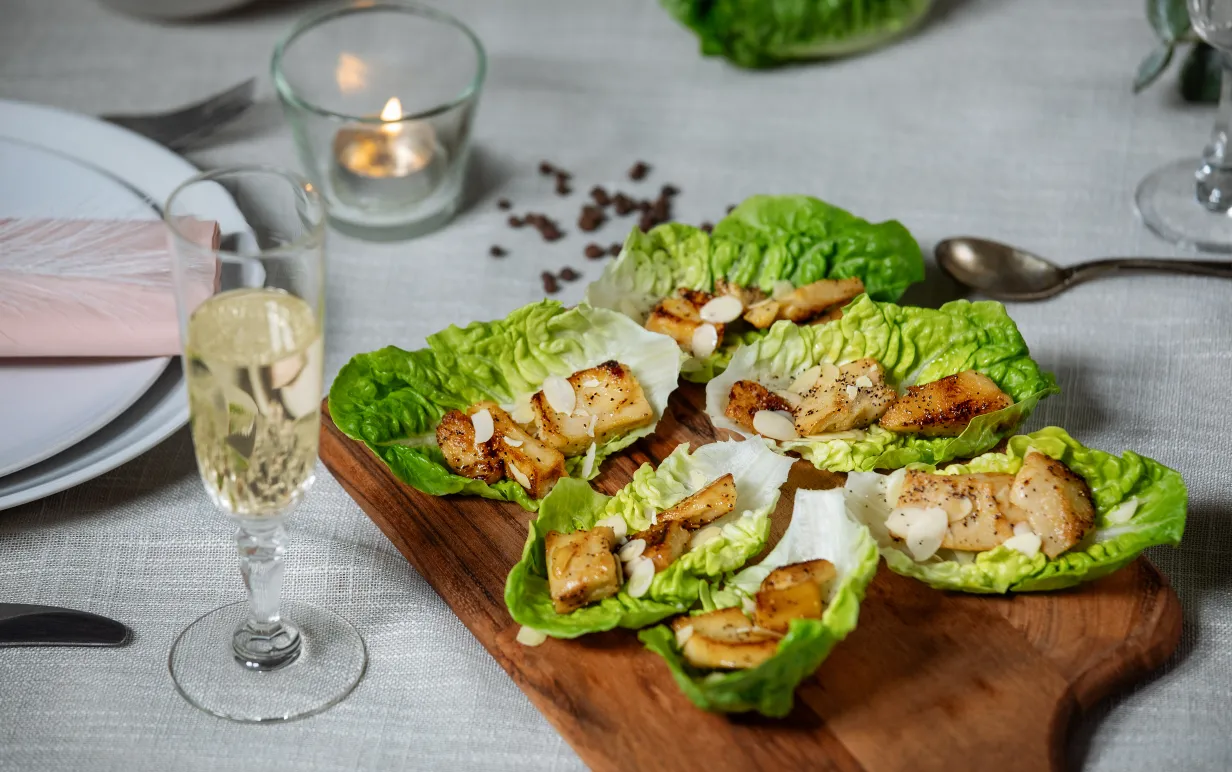 Kryddiga vegobitar på salladsblad ligger på en träbräda