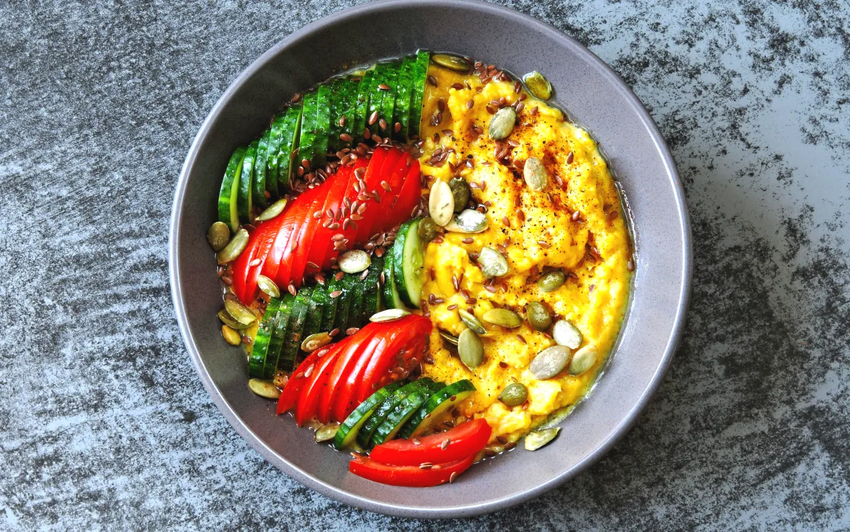 Bowl med grönsaker och polenta på ett bord