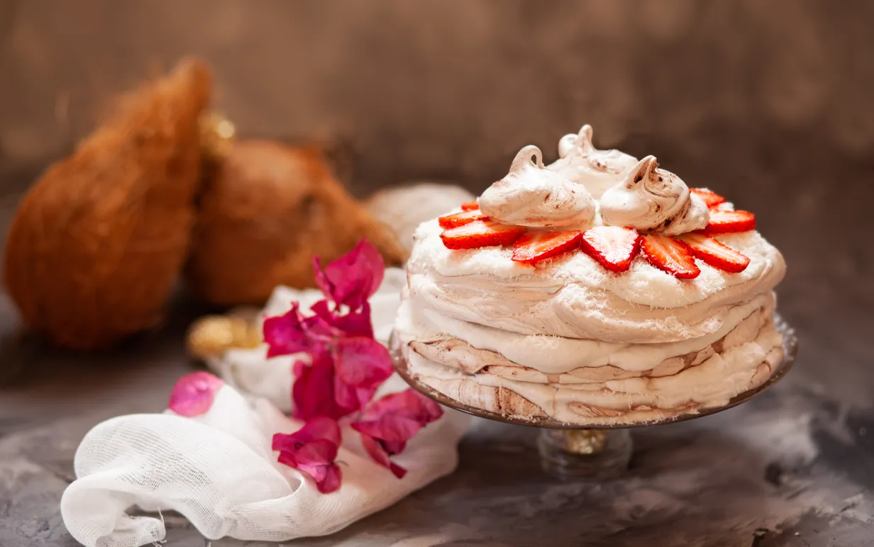 Vegansk marängtårta med jordgubbar på ett fat.