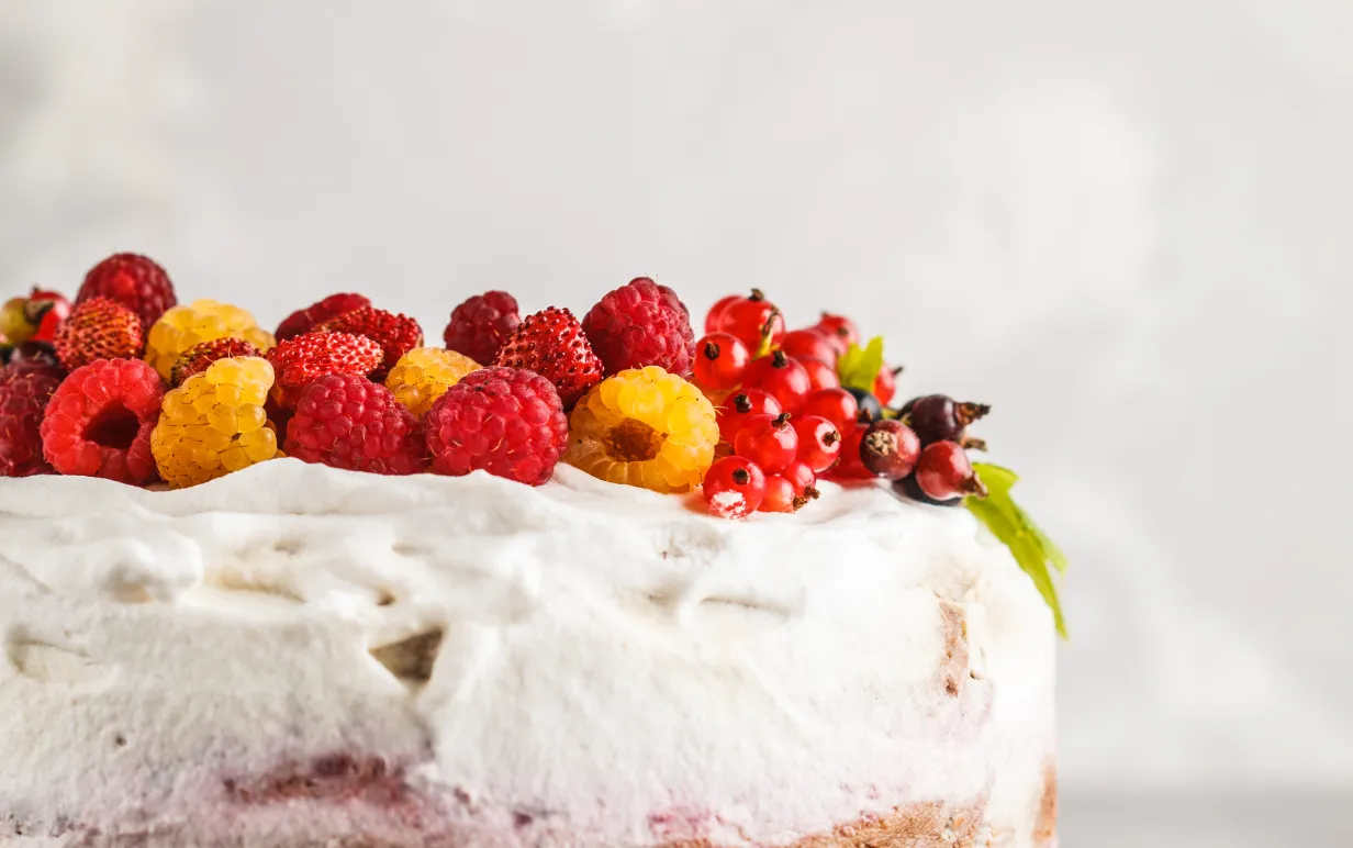 Vegansk somrig tårta toppad med hallon och röda vinbär