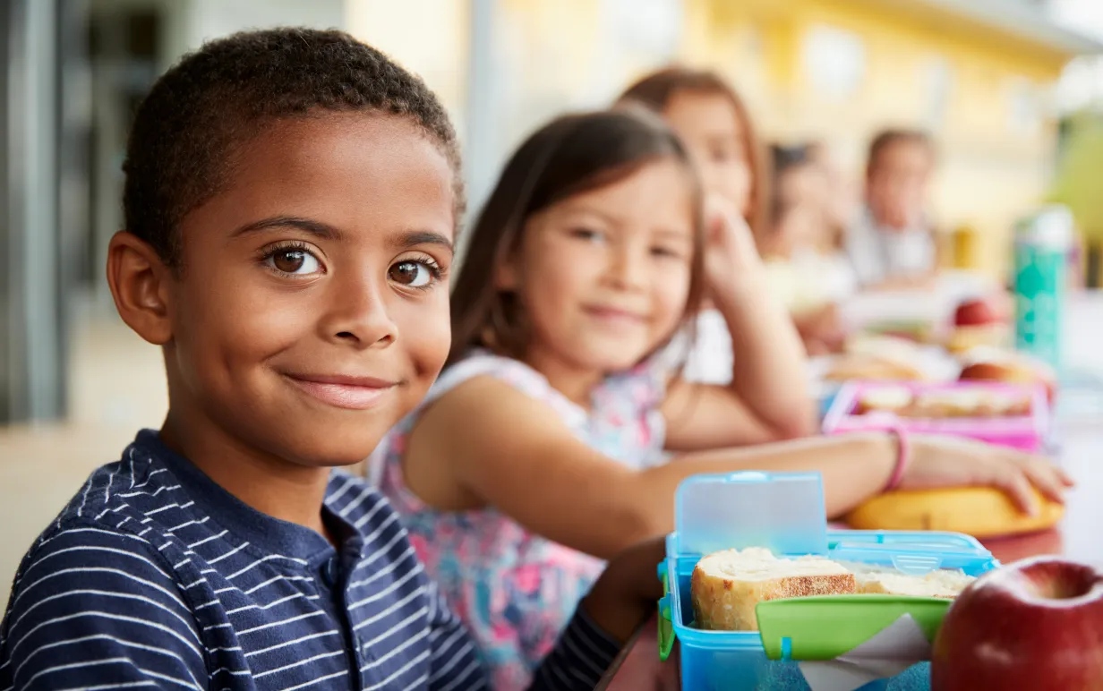 Flera barn sitter på rad, ett barn är i fokus