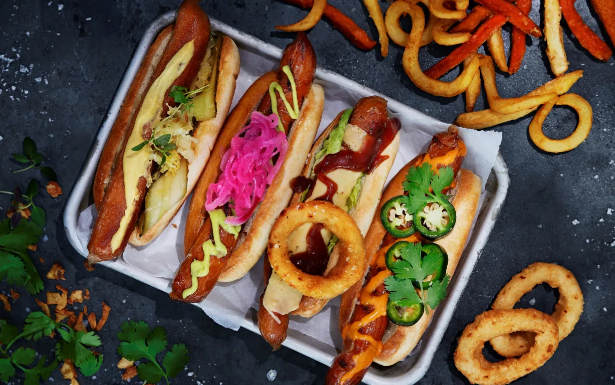 Flera veganska korvar med bröd på en bricka