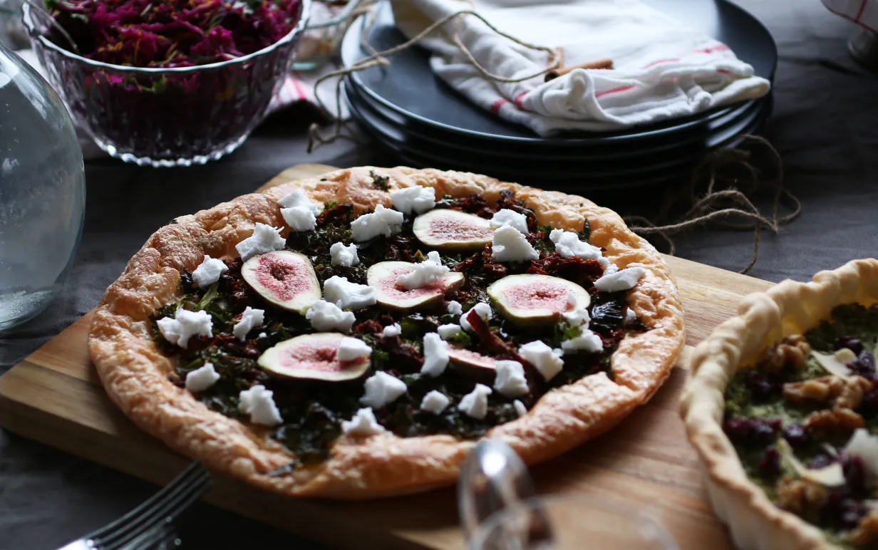 Smördegspaj med grönkål, soltorkade tomater, fikon och vegansk feta på en bräda