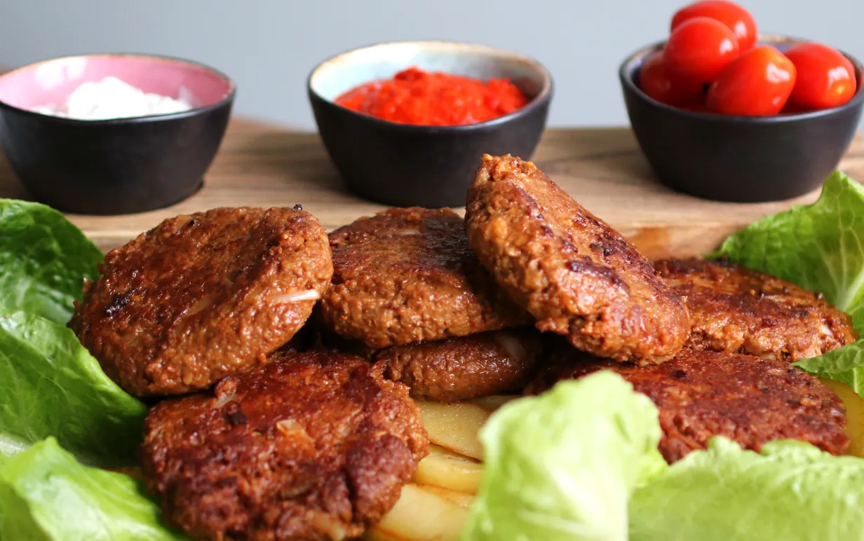 Vegansk Pljeskavica serverad med sallad och klyftpotatis