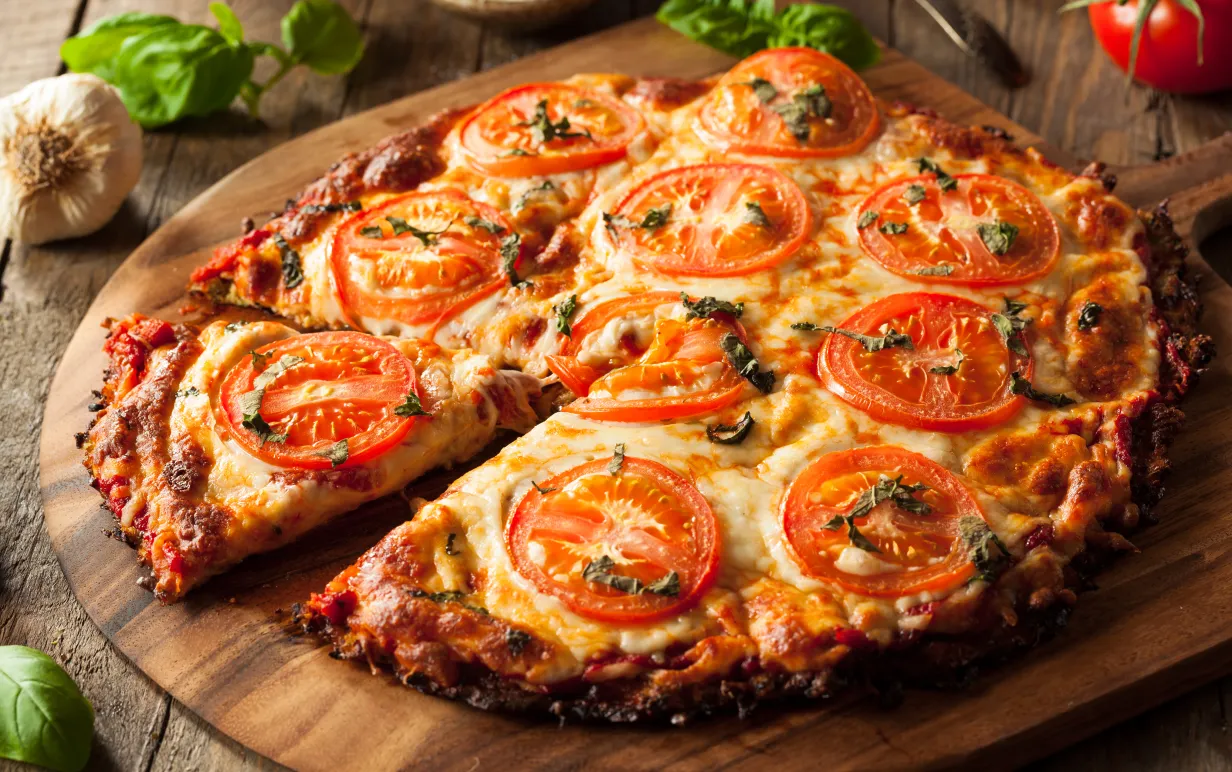 Vegansk pizza på rund träbräda