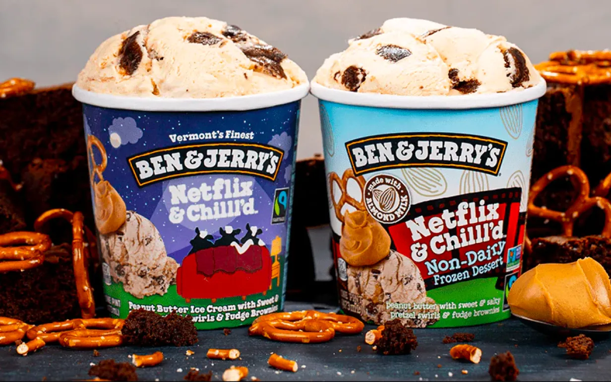 Två tubs med Ben &amp; Jerry's-glass och pretzels, jordnötssmör och brownies i bakgrunden. Tuben till vänster är Netflix &amp; Chill'd icke-vegansk, tuben till höger är Netflix and Chill'd vegansk, non-dairy