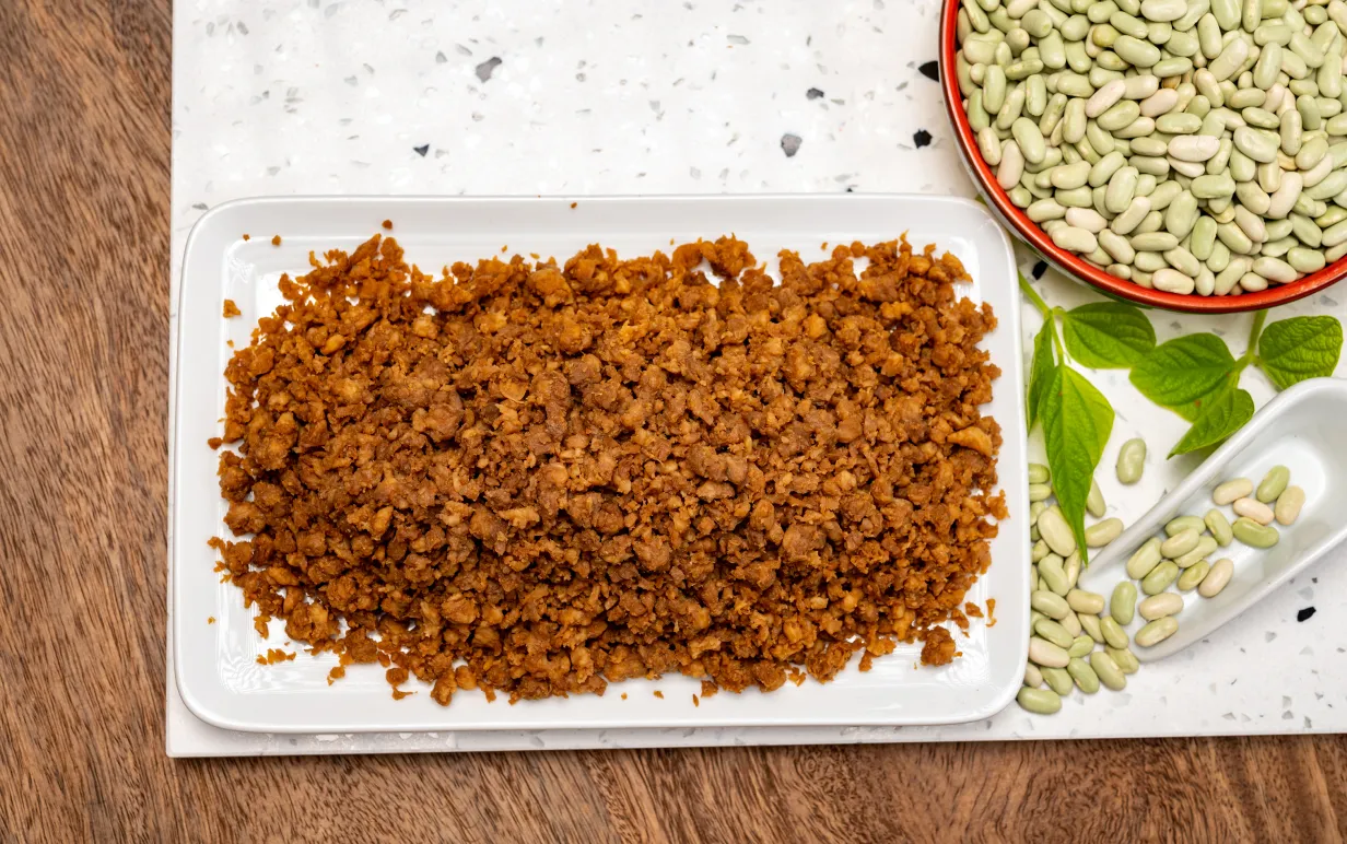 vegansk färs på en tallrik intill okokta bönor