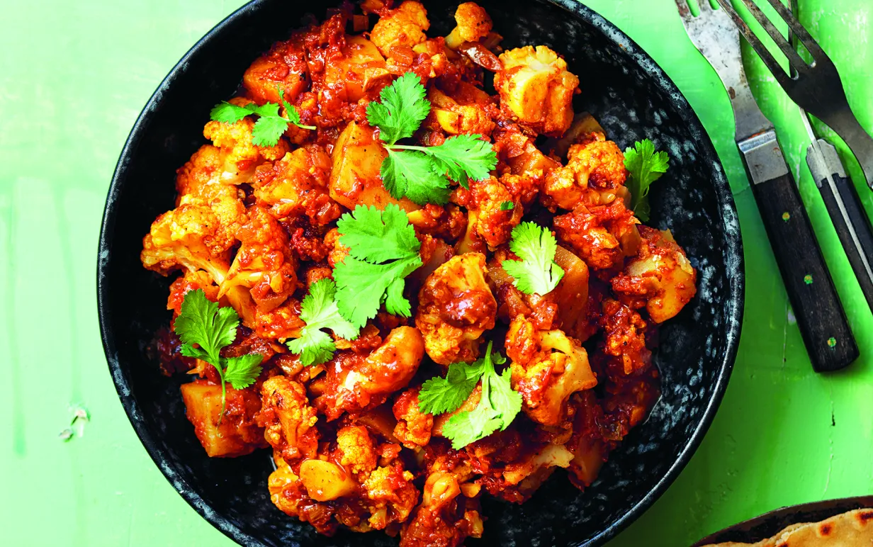 Aloo gobi i djup tallrik på bord.