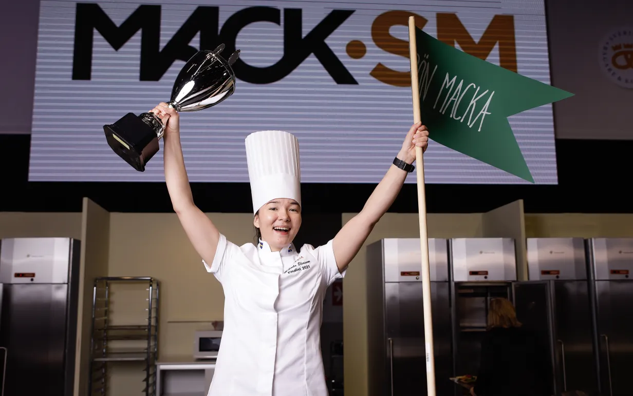 Mikaela Eliasson, vinnare av Mack-SM 2021, med pokal och flagga i händerna.