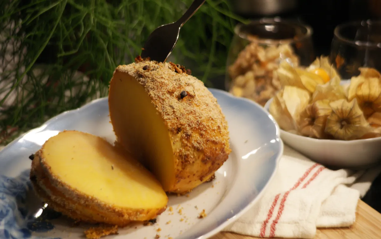 Griljerad kålrot på fat med juliga dekorationer och tillbehör i bakgrunden