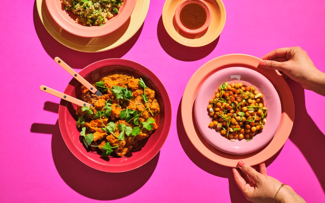 Växbaserade måltider på 4 olika tallrikar mot en rosa bakgrund.