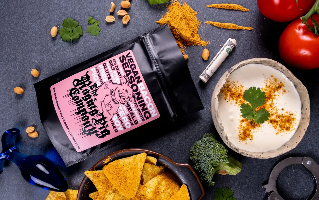 Kryddpåse, dip och nachos utplacerade på ett svart bord.