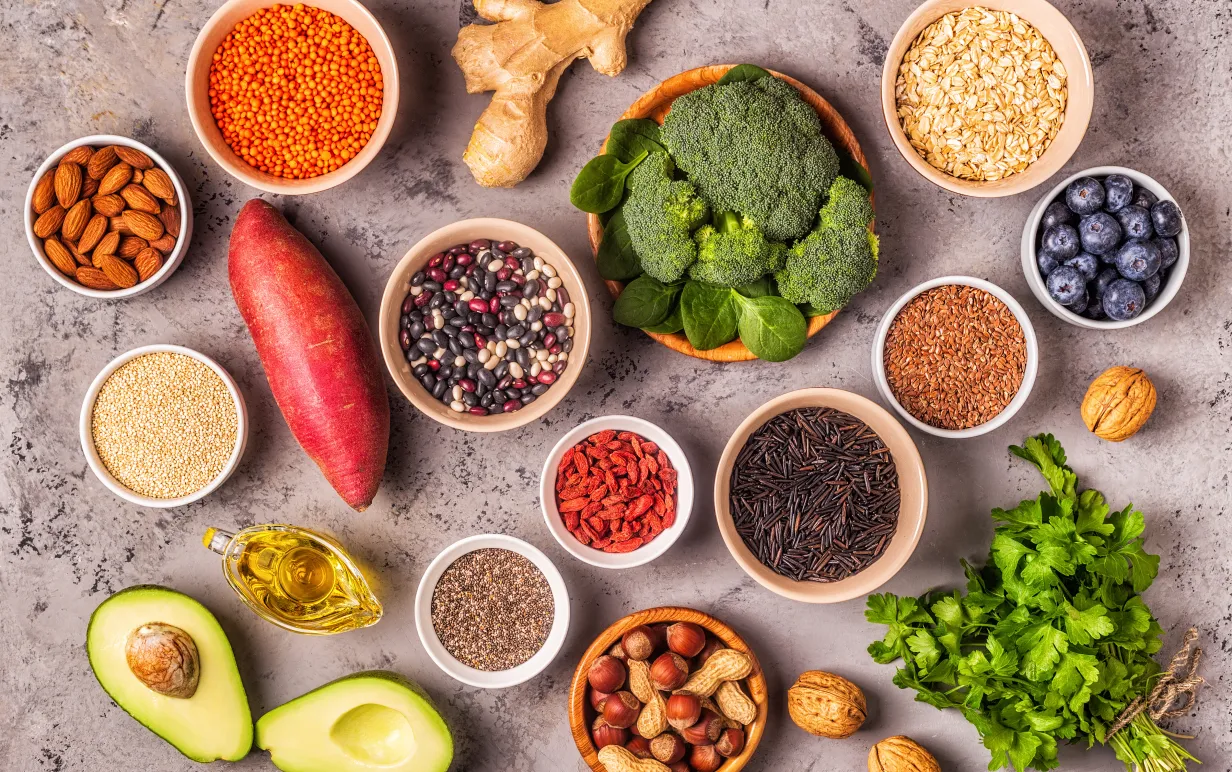 Växtbaserade råvaror uppdukade i skålar på ett grått bord.