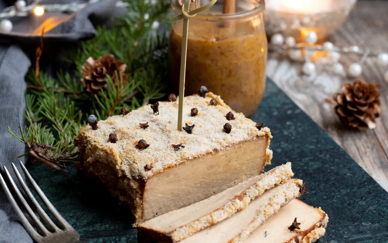 Griljerad tofu på en mörk marmorplatta på ett uppdukat julbord.