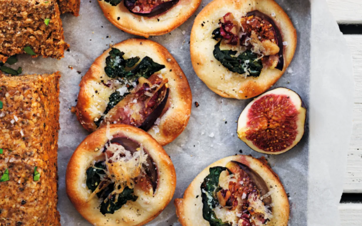 Minipizzor med svartkål och fikon på bakplåtspapper
