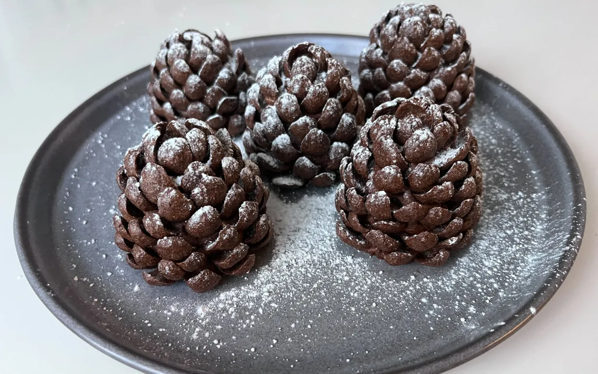 En tallrik med fem kladdkakekottar på ett vitt bort