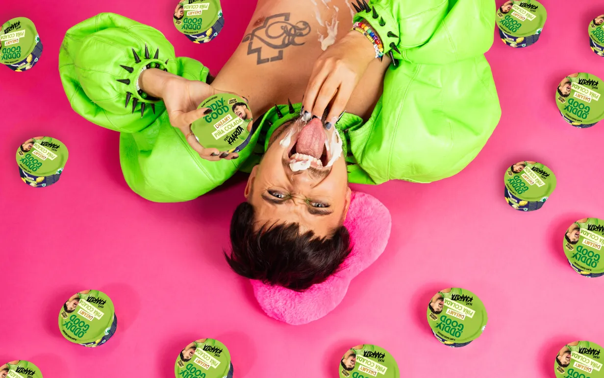 En man i gröna kläder ligger på en rosa bakgrund