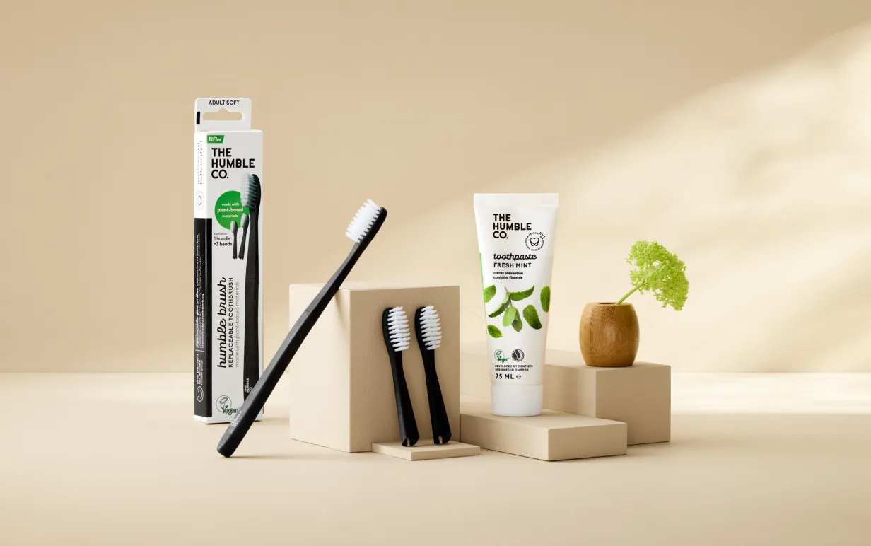 Tandborstar och tandkrämer som är placerade mot en beige bakgrund