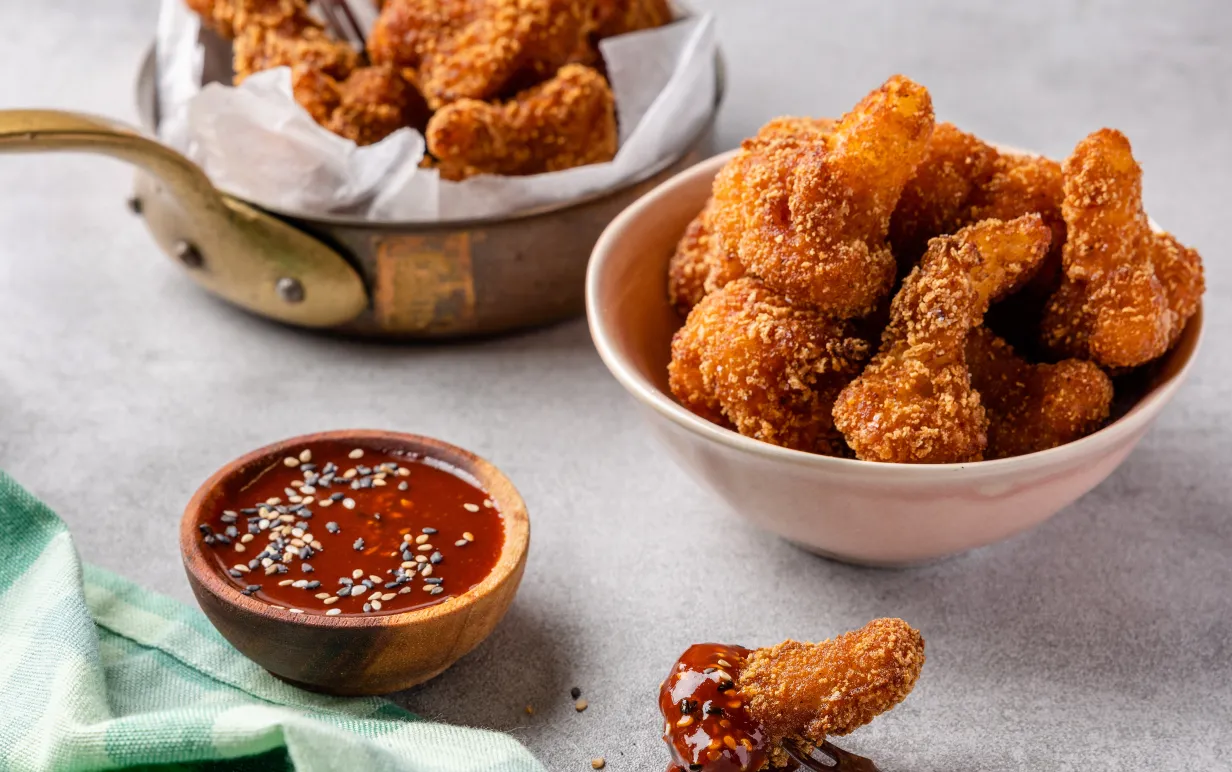 Två skålar med friterad blomkål i, samt en mindre skål med sås.