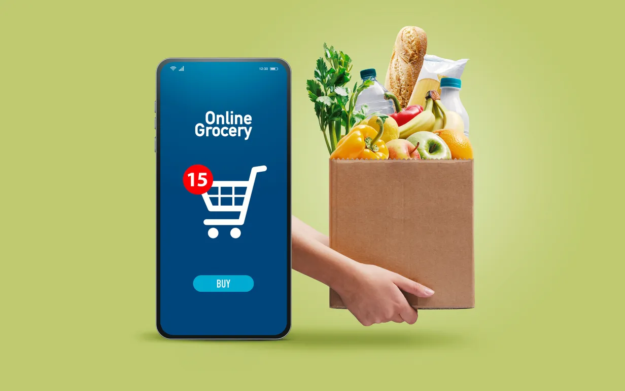 En matkasse med grönsaker och en mobil med en shoppingkorg mot en grön bakgrund