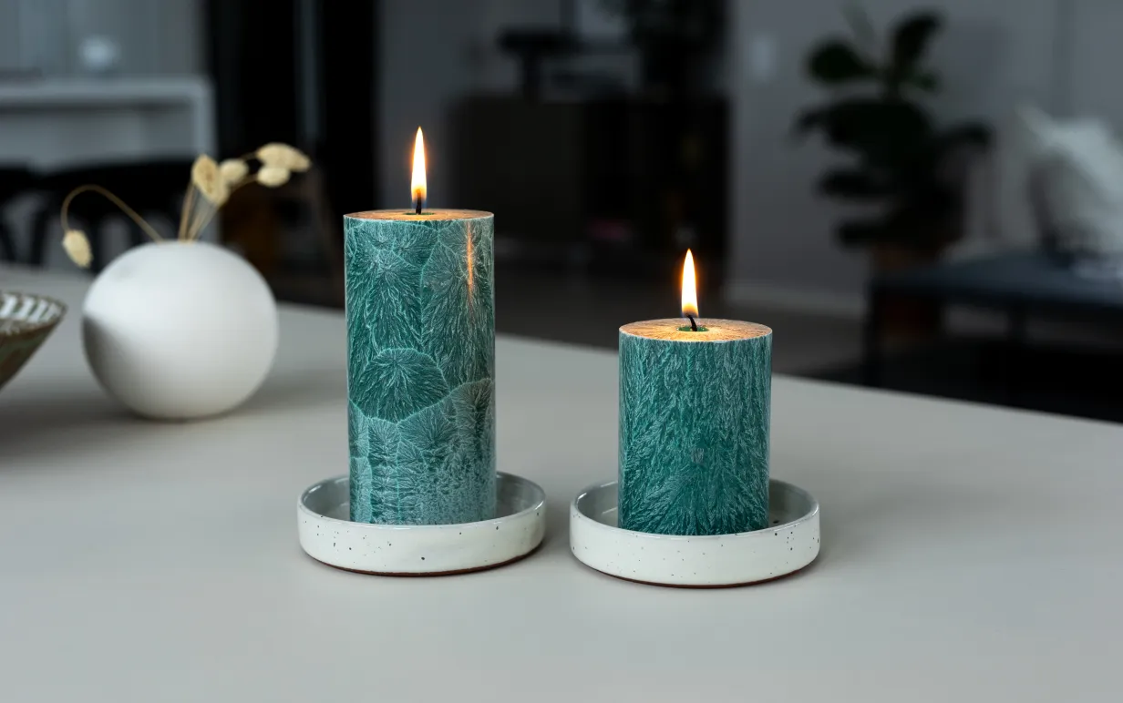 Två tända blockljus på ett bord