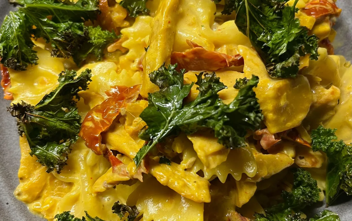 En djuptallrik med saffranspasta, grönkål och soltorkade tomater