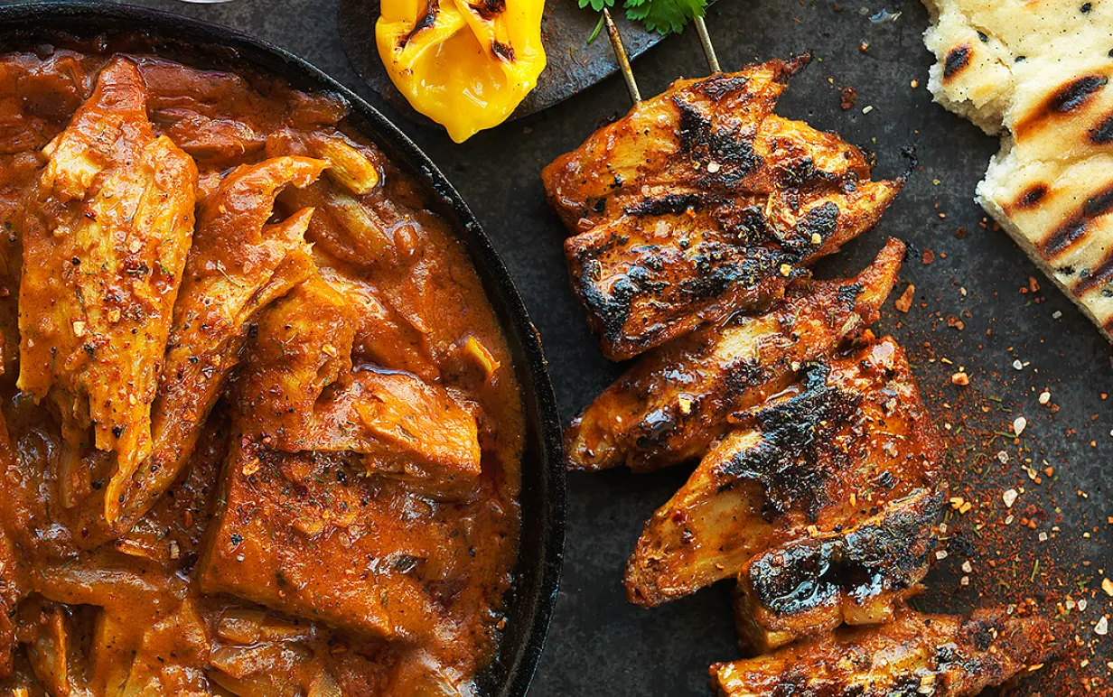 Vegansk Tikka Masala på ett spett bredvid en tallrik