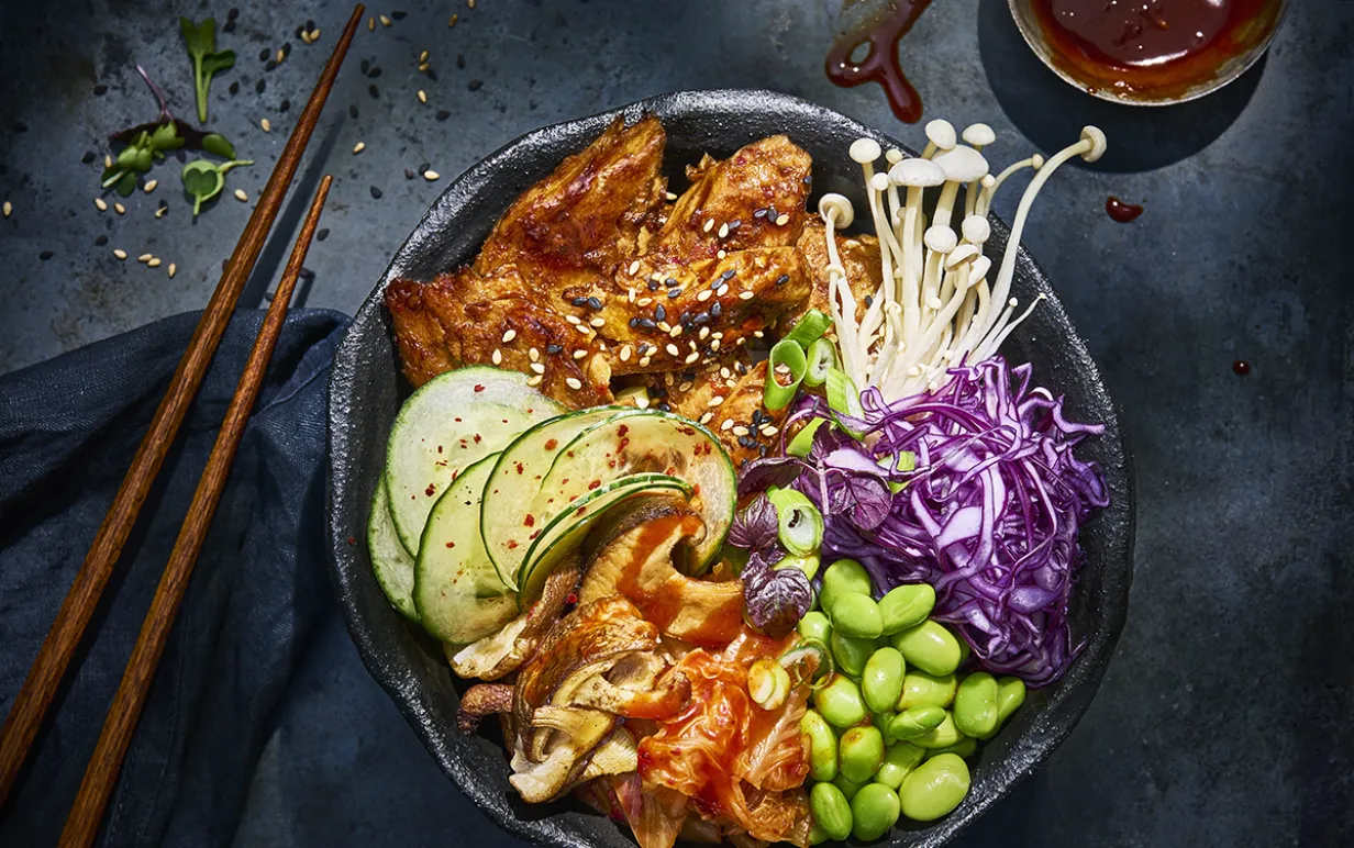 Koreansk grönsaksbowl i en svart djuptallrik på ett svart bord