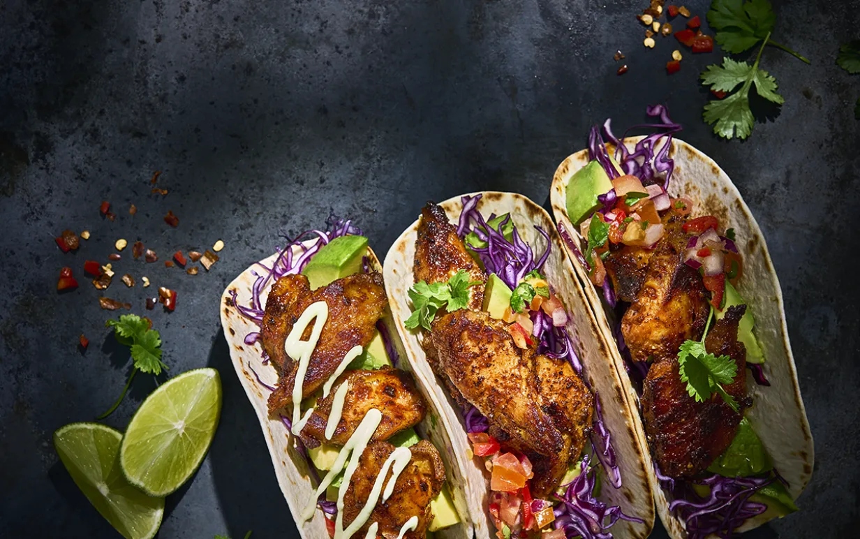 Tre mjuka tacos på ett svart bord