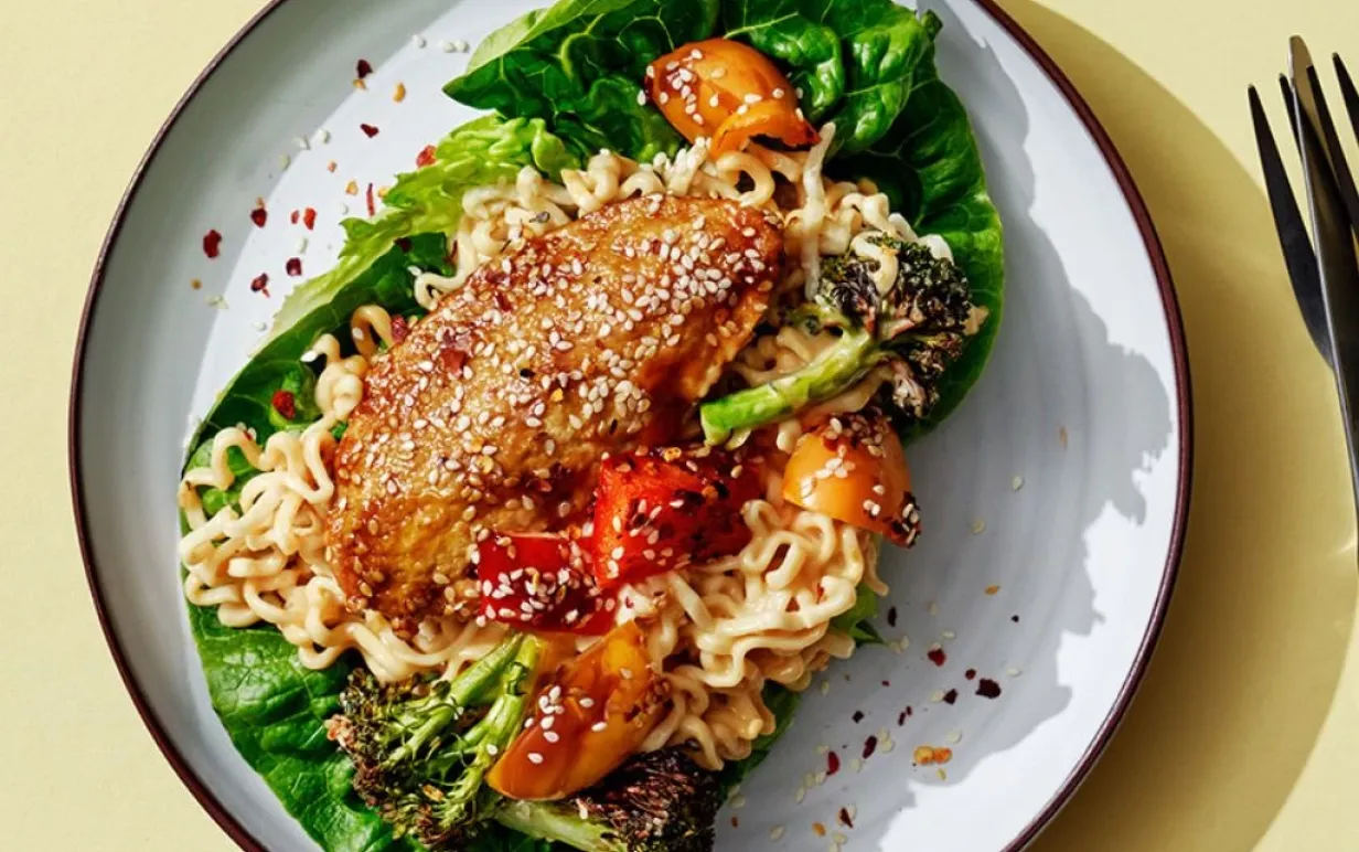 Vegofiléer med med nudlar och sallad på en tallrik, på ett gult bord