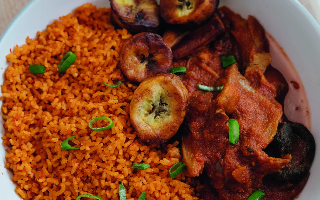 Jollof ris med stekt kokbanan i en djuptallrik