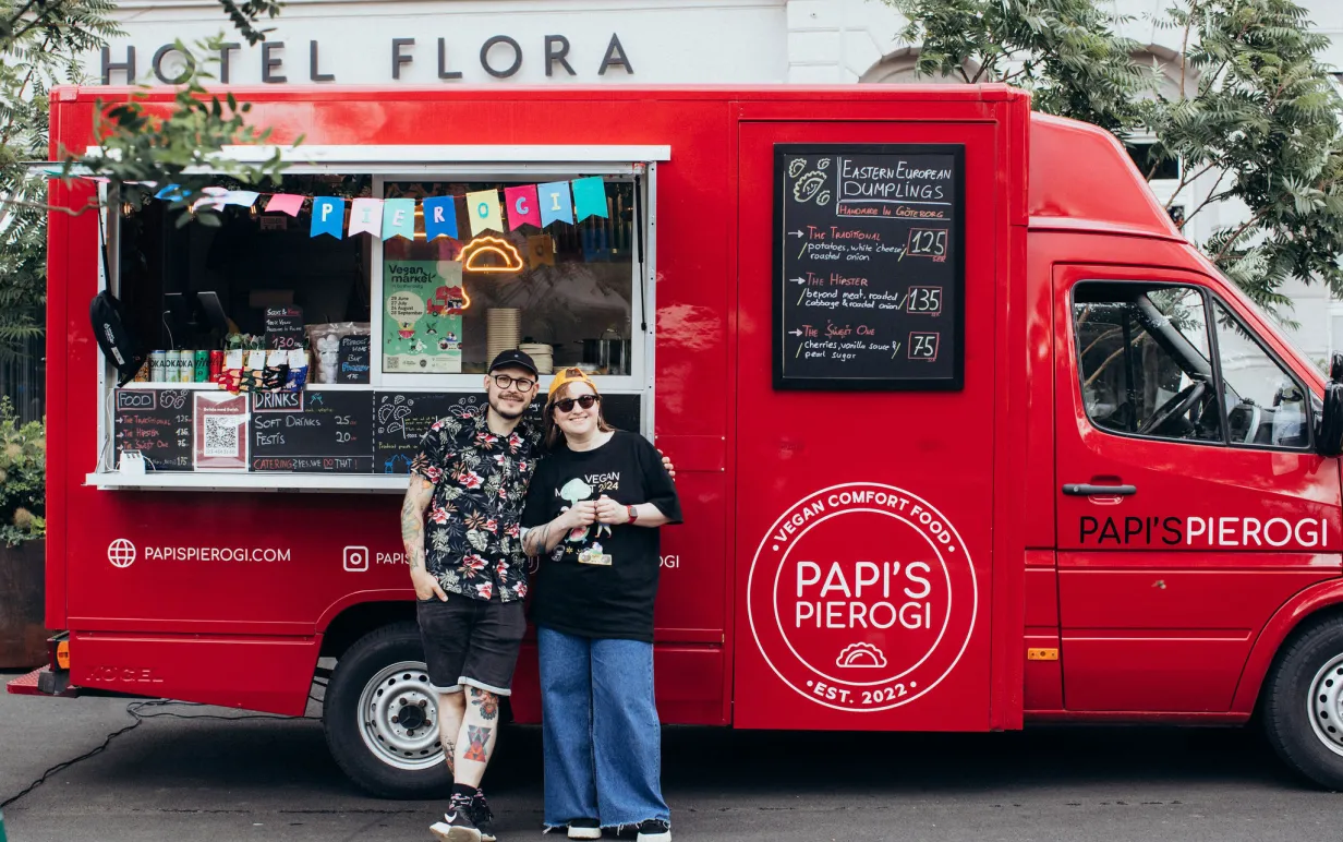 Två personer framför en röd van