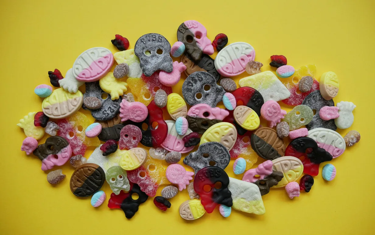 En hög med veganska godisar på en gul bakgrund.