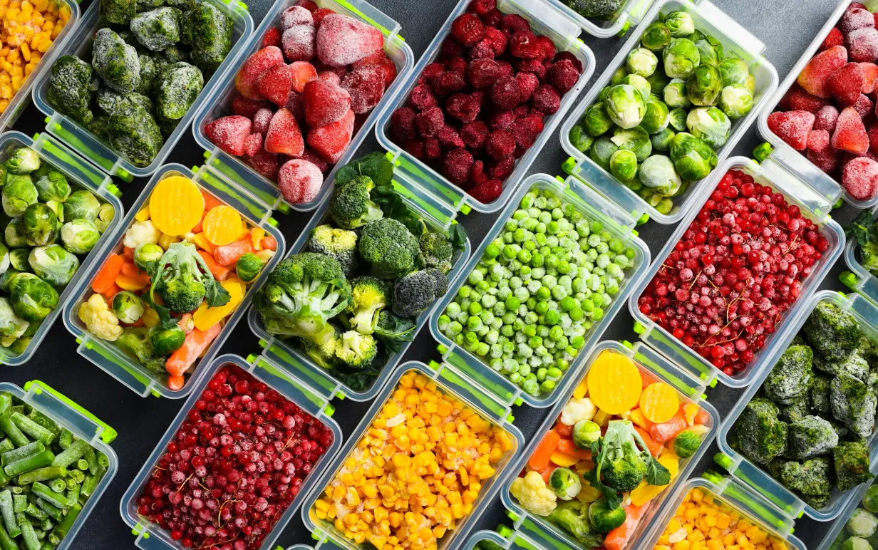Frysta grönsaker uppradade i matlådor