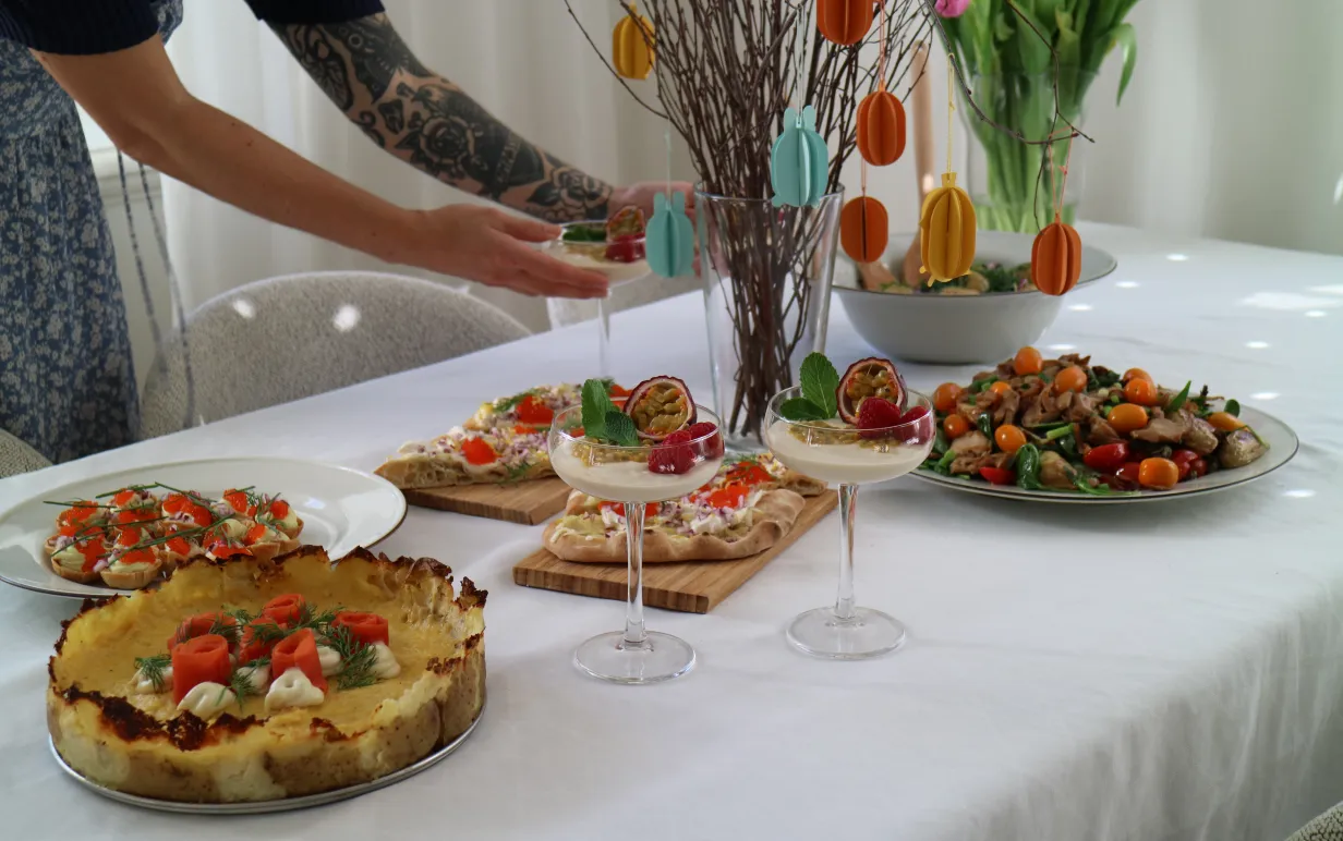 Veganskt påskbord och tjej med en tatuerad arm som håller i cocktailglas
