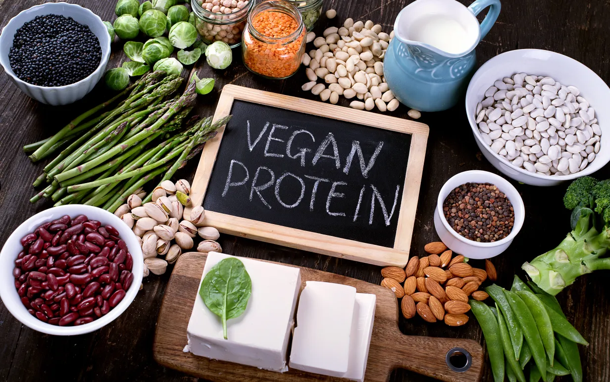 Bild på svart skrivtavla med texten vegan protein, omringad av diverse grönsaker