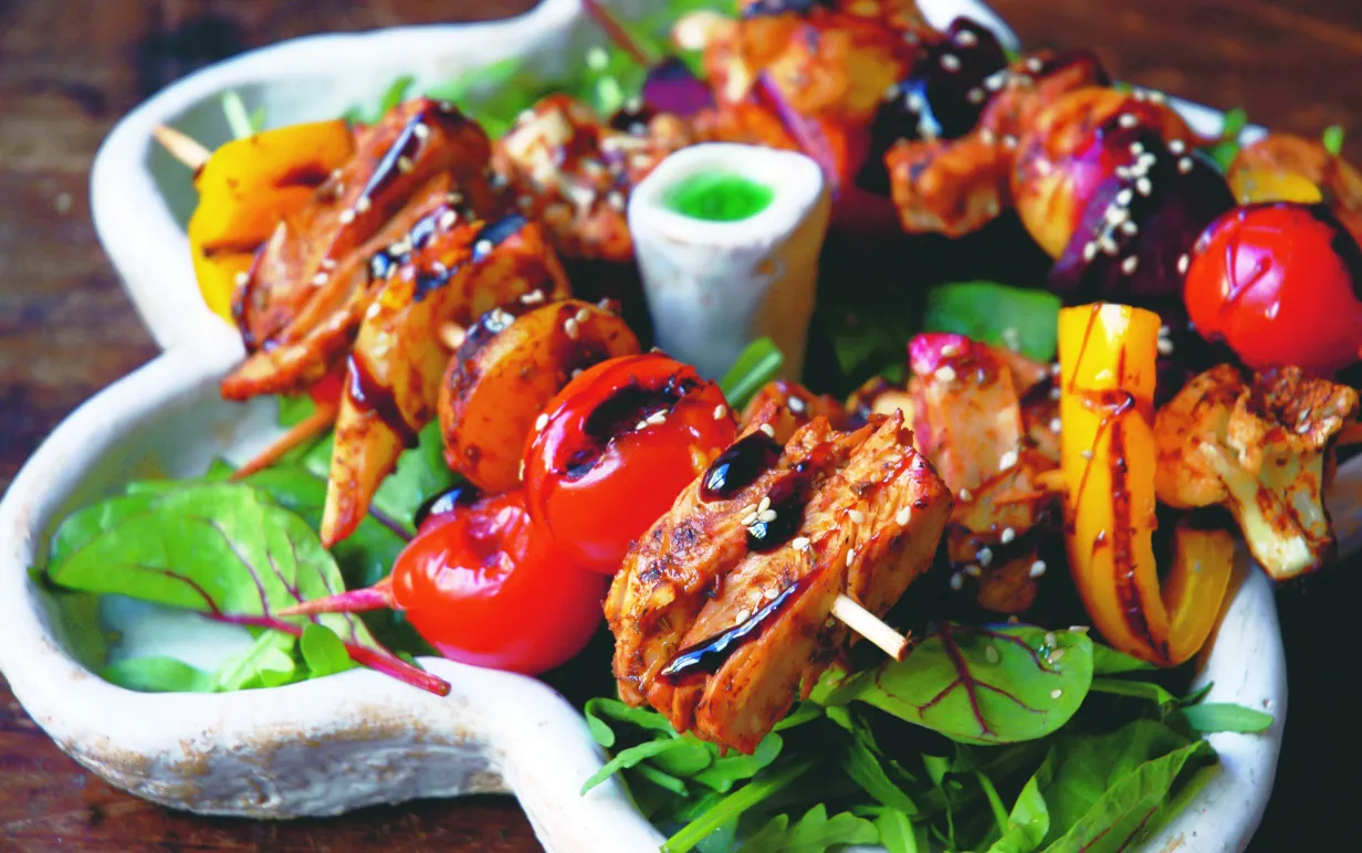 Grillspett i BBQ-marinad med sallad på ett vitt fat