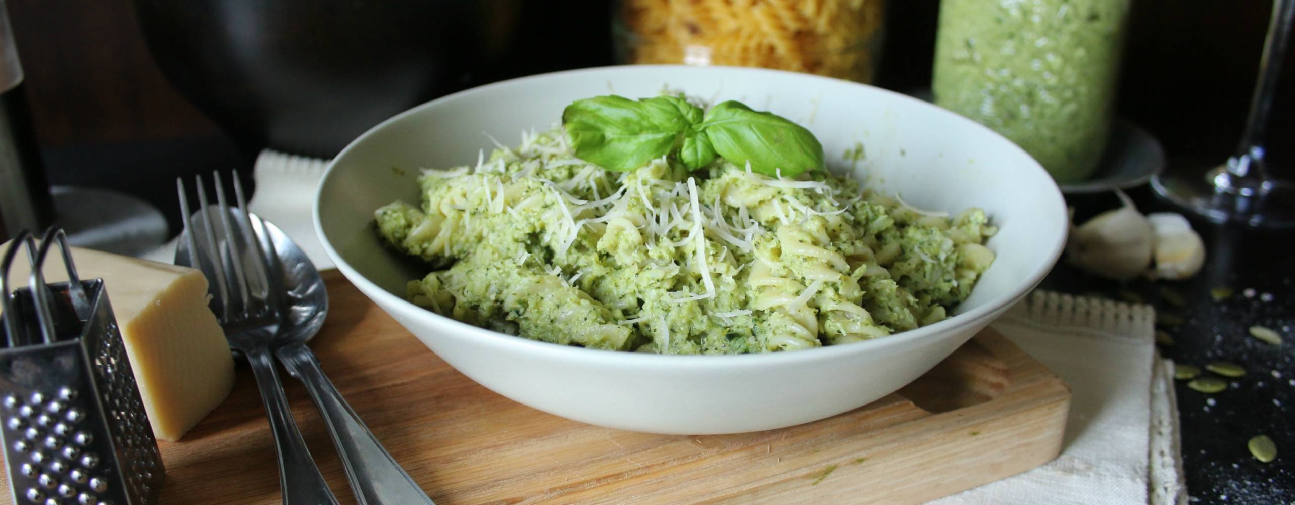 Broccolipesto med pasta i en vit tallrik på en skärbräda