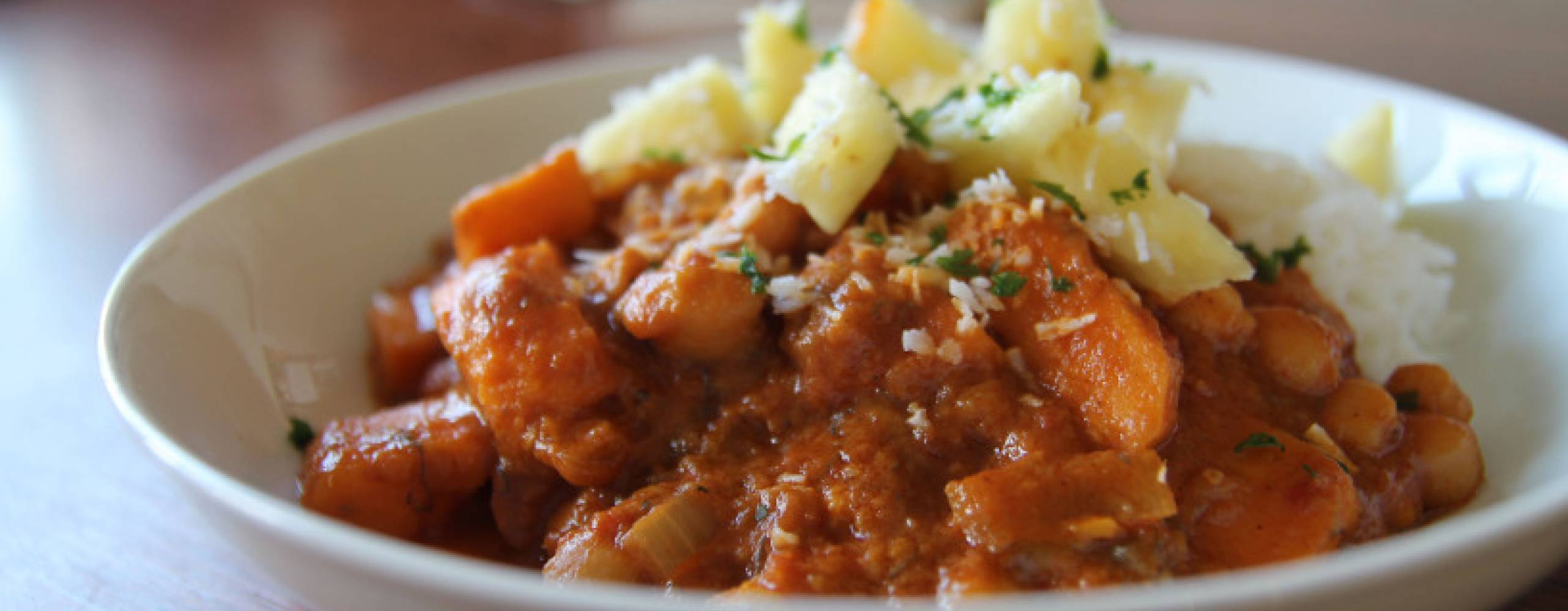 Starksöt gryta med ris och ananasbitar på en vit tallrik.