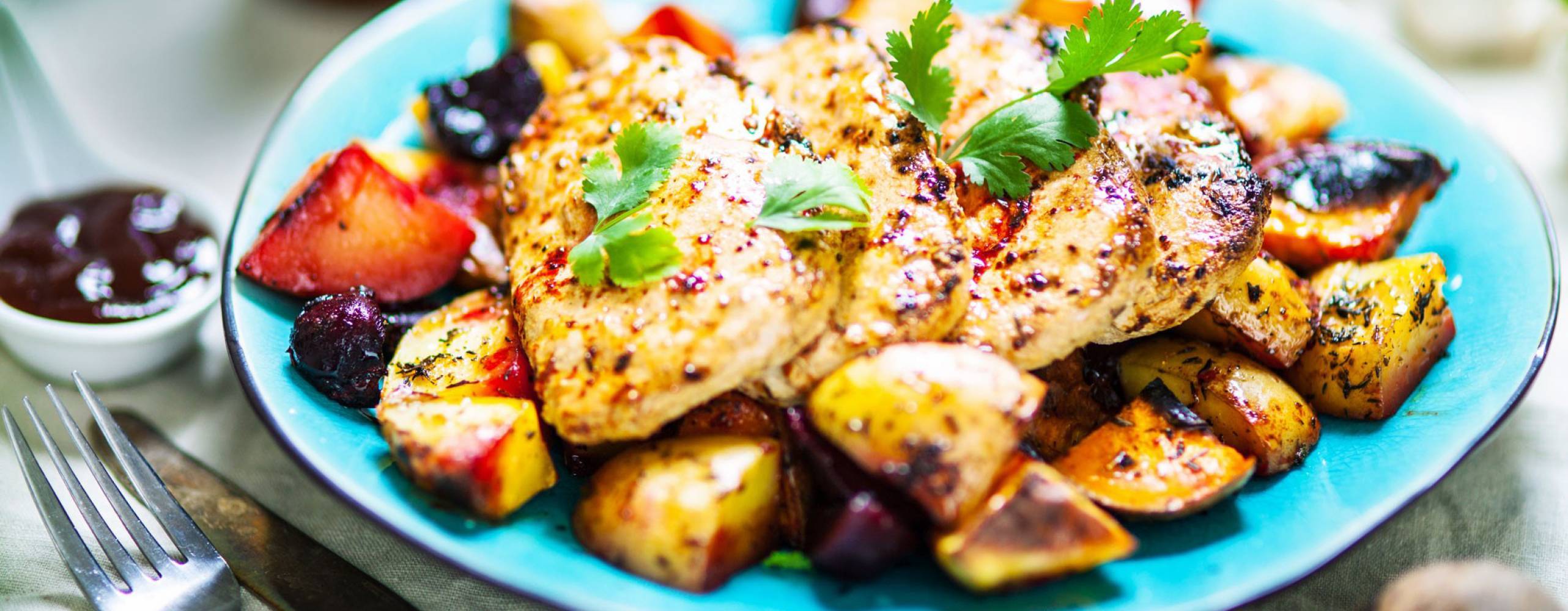 Ugnsrostade grönsaker och scallopini på en turkos tallrik