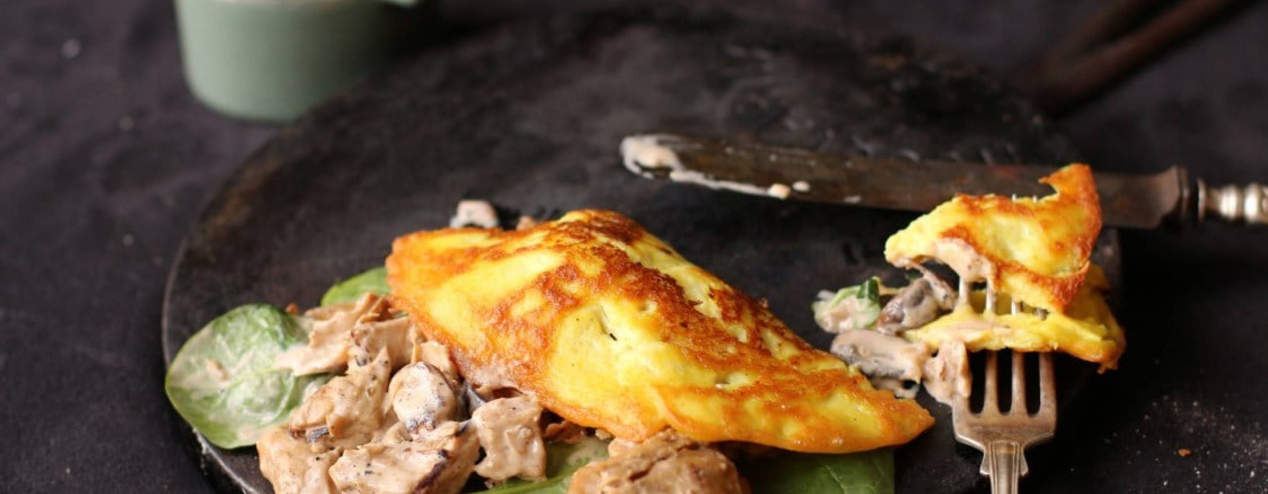 Omelette med oumph på en svart tallrik på ett svart bord.