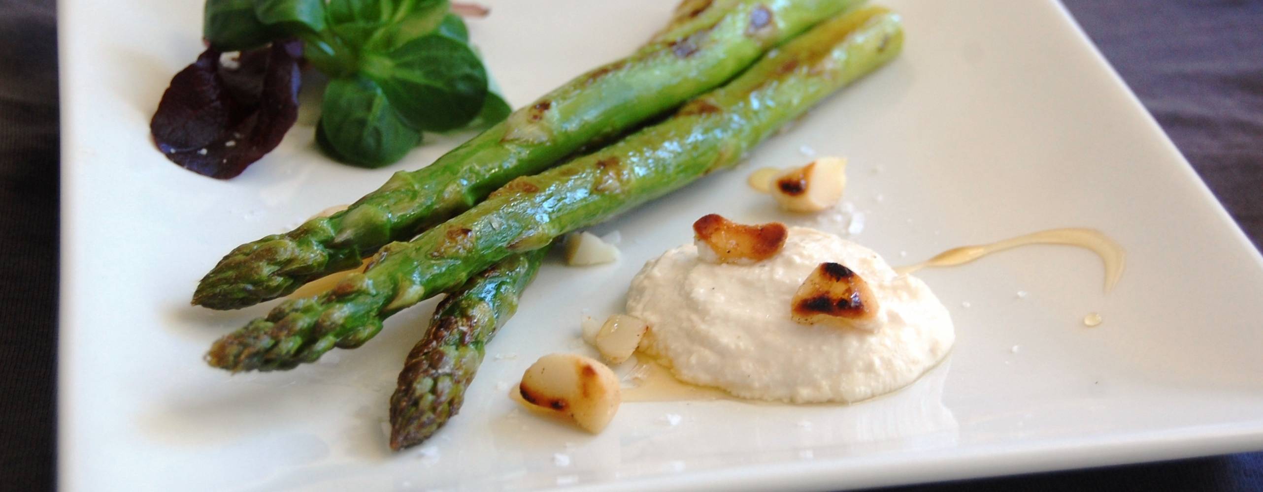 Fräst sparris med vegansk ädelostkräm på en vit tallrik.